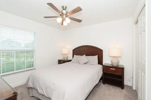 a bedroom with a bed and a large window