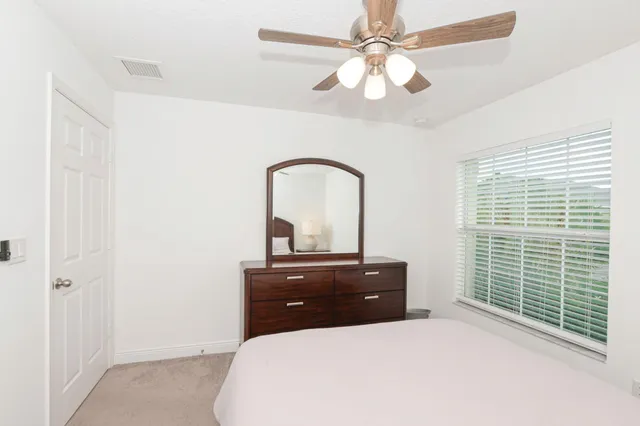 a bedroom with a bed and a ceiling fan