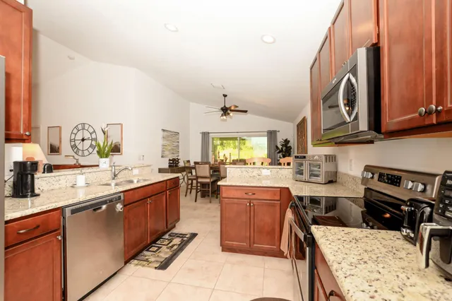 a kitchen with stainless steel appliances granite countertop a sink stove and cabinets