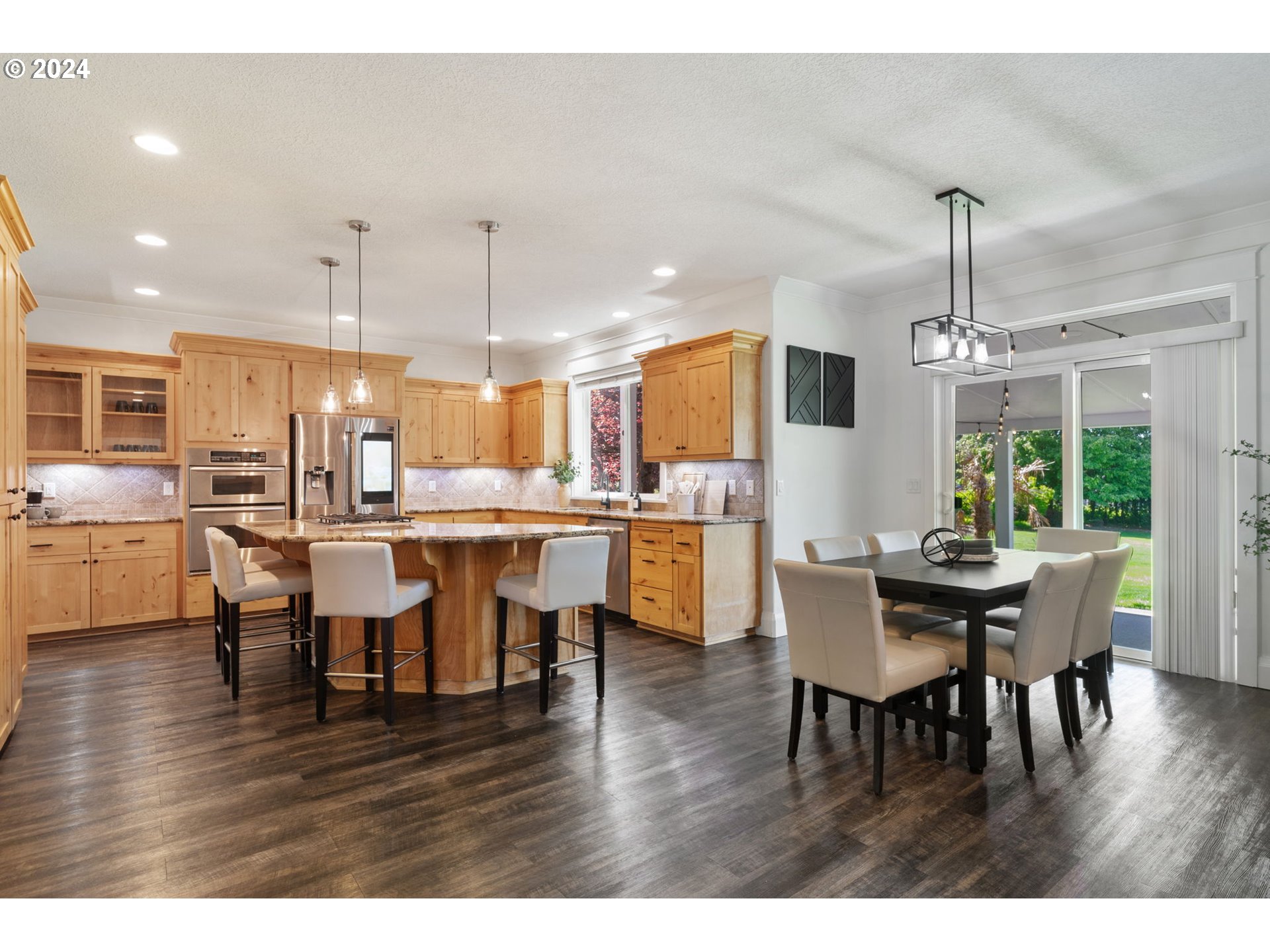 29090 Southeast Powell Valley Road Gresham, OR 97080 - Photo 13 of 45 a dining room with stainless steel appliances kitchen island granite countertop a table chairs and a microwave