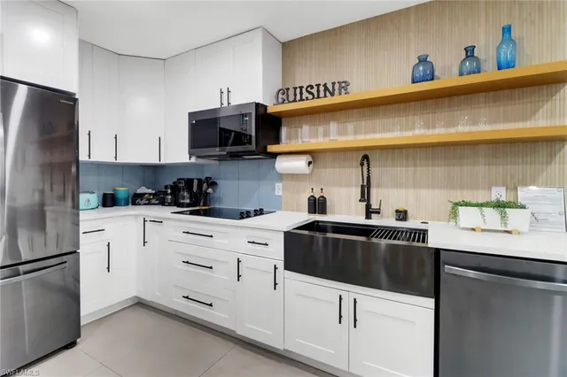 a kitchen with stainless steel appliances a sink a stove and refrigerator
