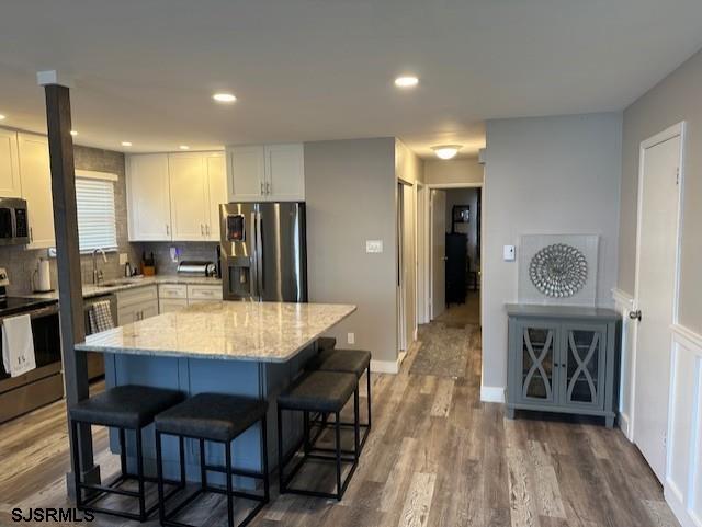 251 4th Street South, Unit 9 Brigantine, NJ 08203 - Photo 8 of 19 a large kitchen with a table chairs and a wooden floor