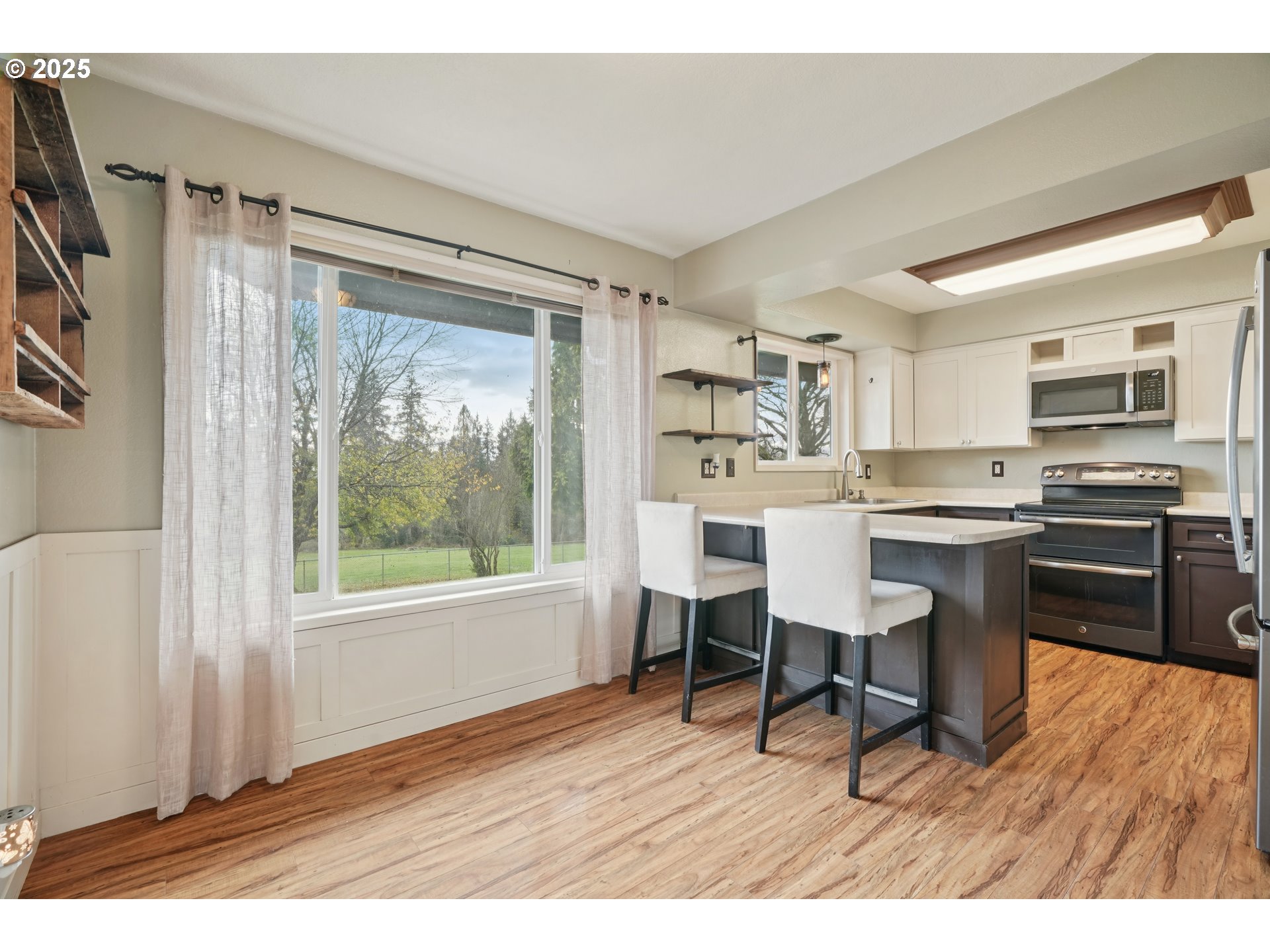 130 Stella Lane Longview, WA 98632 - Photo 9 of 41 a open kitchen with stainless steel appliances granite countertop a stove top oven a sink dishwasher and white cabinets with wooden floor