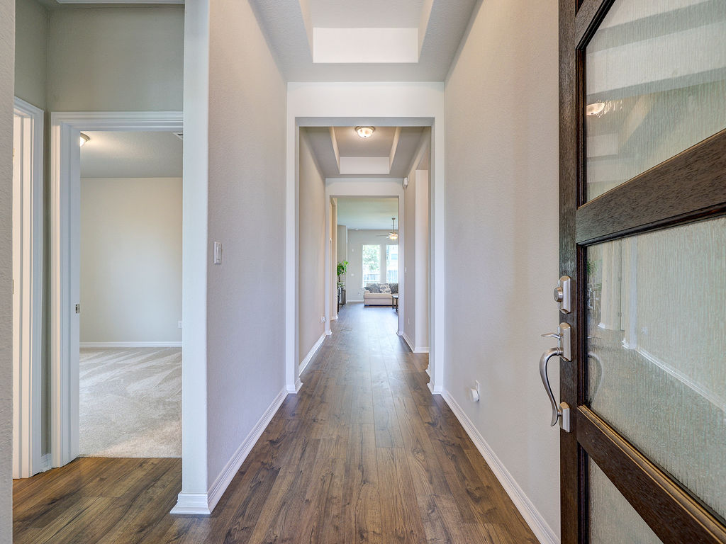 229 Heartleaf Road San Marcos, TX 78666 - Photo 7 of 40 A welcoming entryway with rich wood-look flooring leads to an inviting open living area.
