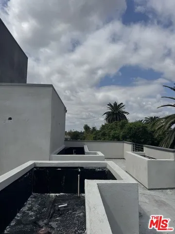 a view of roof deck with chairs and barbeque grill