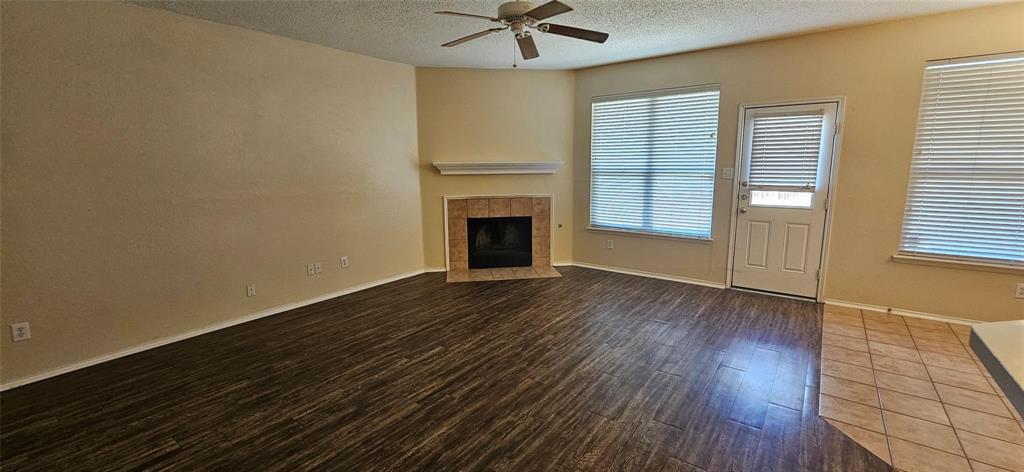2820 Deer Ridge Drive Rockwall, TX 75032 - Photo 3 of 14 an empty room with wooden floor fireplace and windows