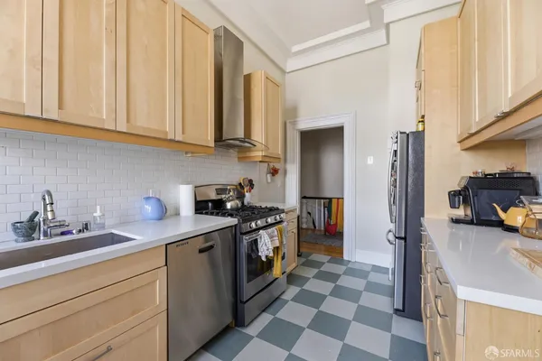 a kitchen with stainless steel appliances granite countertop a sink and a refrigerator