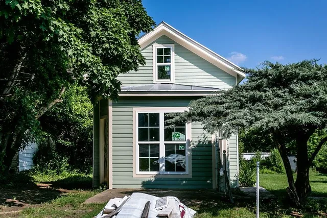 a view of a house with a tree in front of it