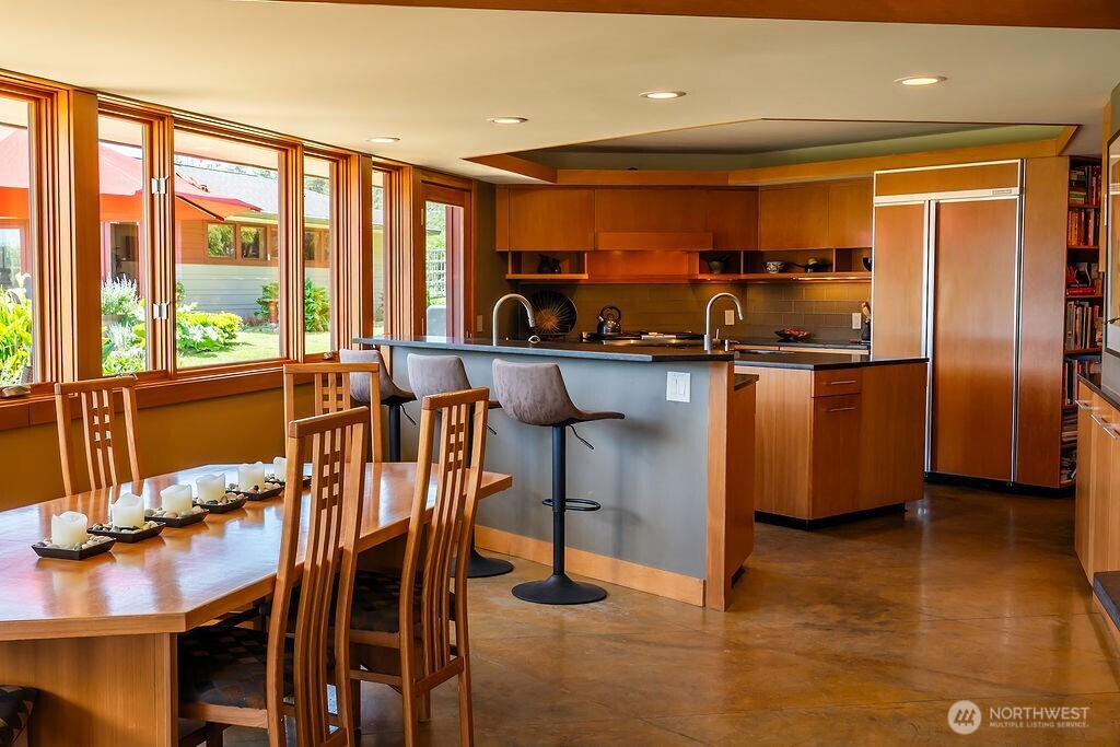 2000 Bayshore Road Lopez Island, WA 98261 - Photo 9 of 40 a kitchen with stainless steel appliances granite countertop a stove top oven a sink a dining table and chairs with wooden floor