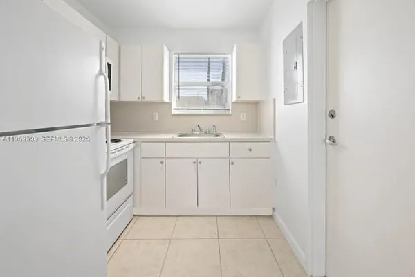 a view of a kitchen with white cabinets