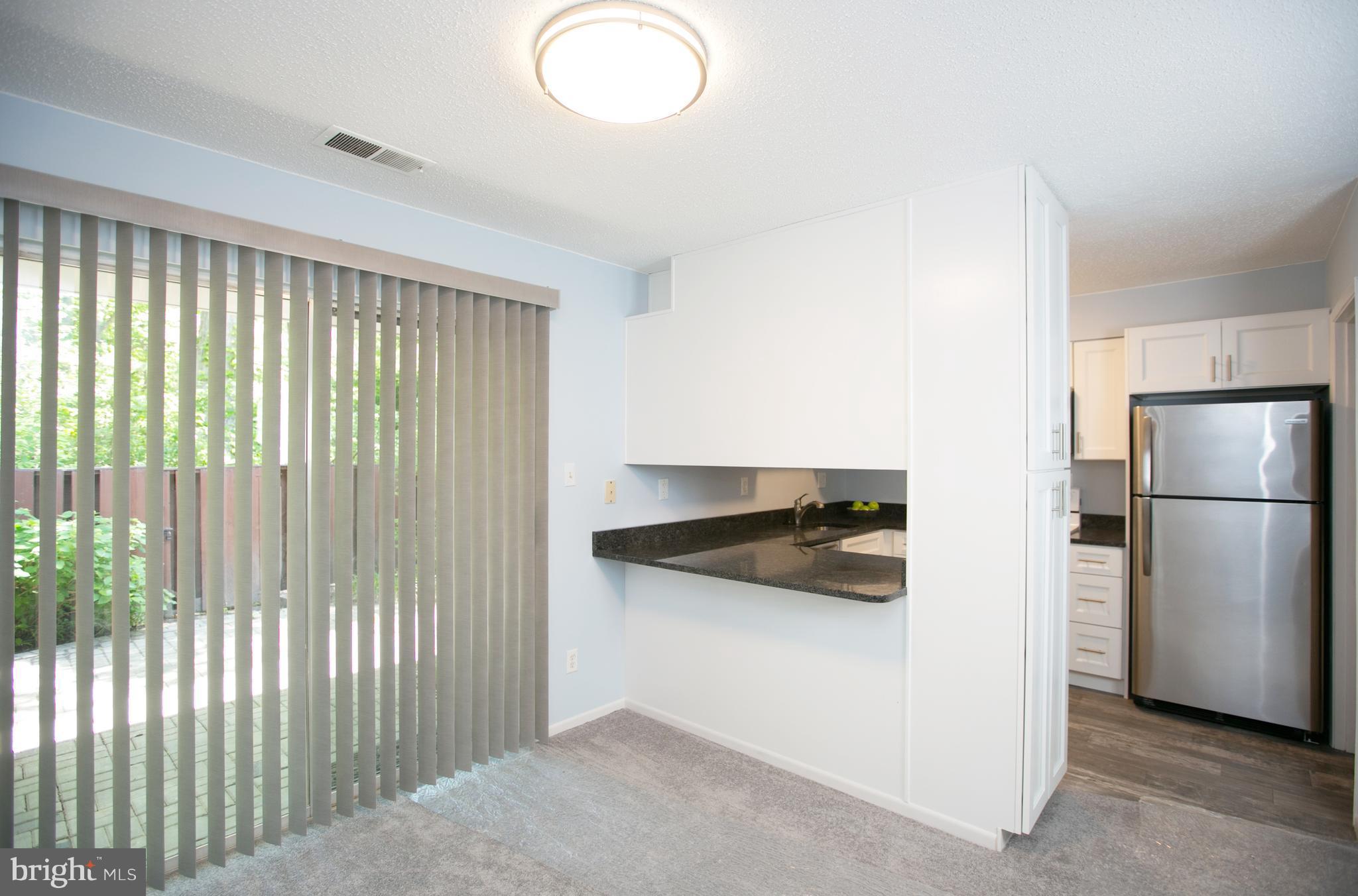 2330 Southgate Square Reston, VA 20191 - Photo 7 of 28 a kitchen with a refrigerator and white cabinets