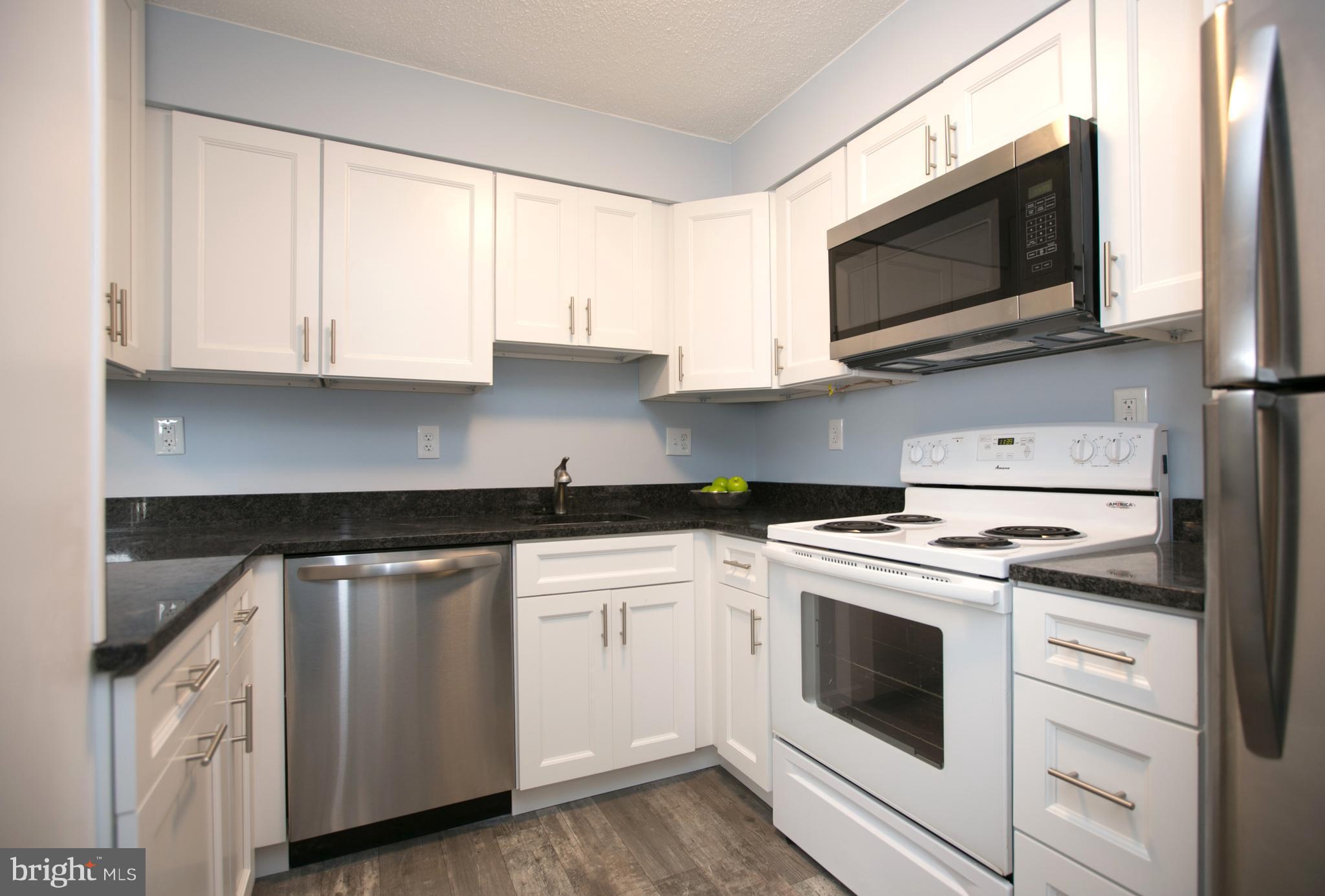 2330 Southgate Square Reston, VA 20191 - Photo 9 of 28 a kitchen with white cabinets stainless steel appliances and sink
