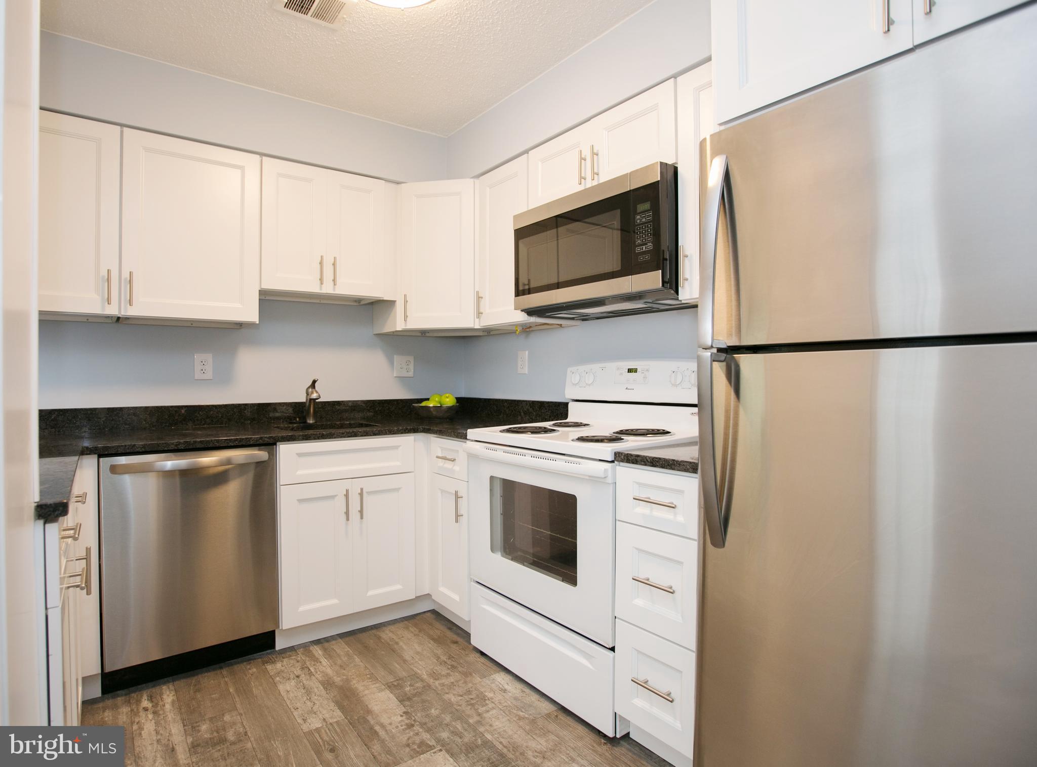 2330 Southgate Square Reston, VA 20191 - Photo 10 of 28 a kitchen with white cabinets and white appliances