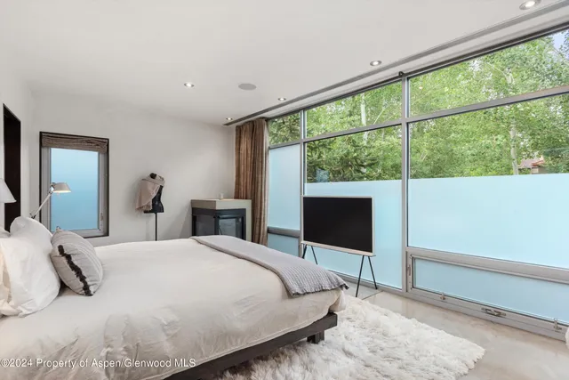 a bedroom with a large bed and a flat tv screen on dresser