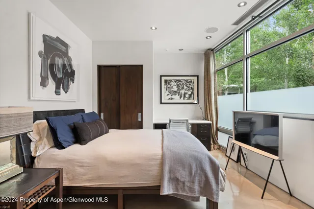 a bedroom with a bed and glass windows