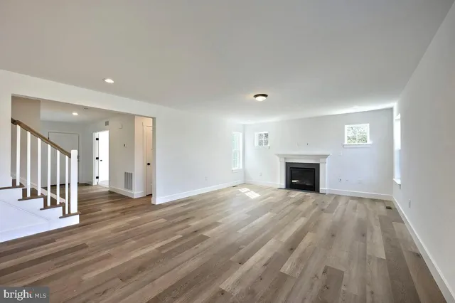 a view of empty room with wooden floor and fireplace