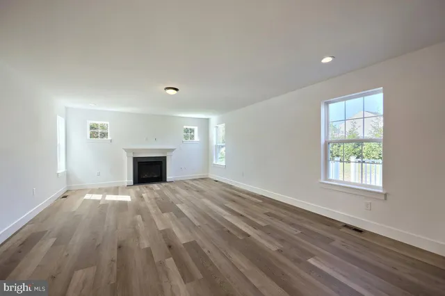 wooden floor fireplace and windows in an empty room