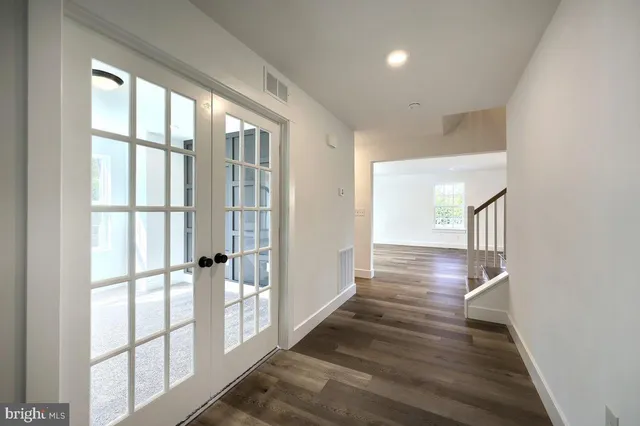 a view of hallway with wooden floor and cabinet