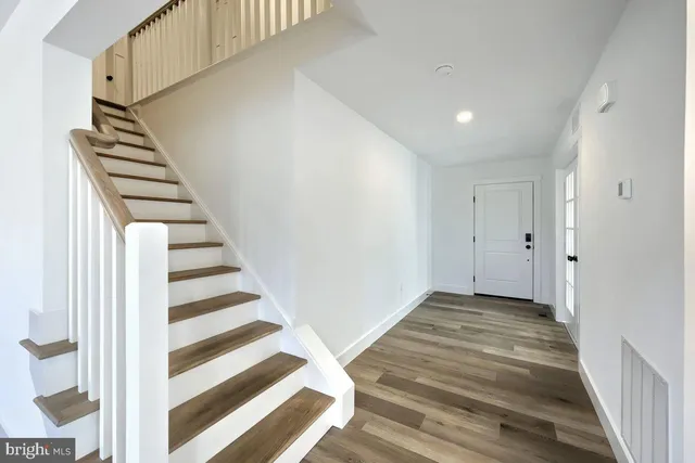a view of a hallway with wooden floor and entryway