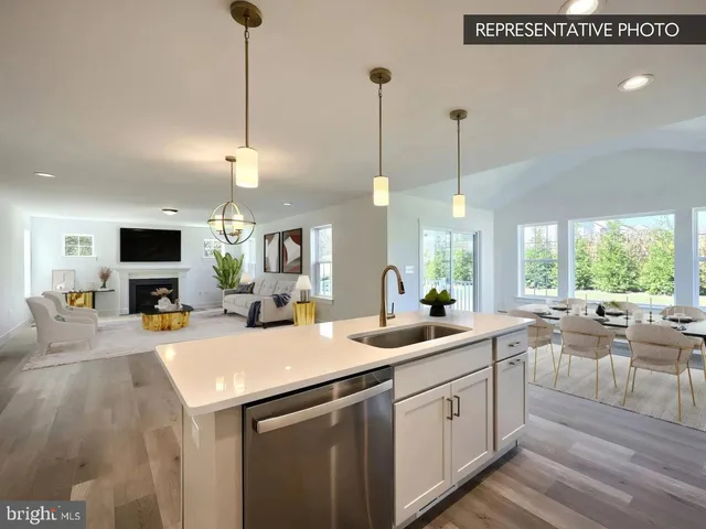 a large kitchen with kitchen island a stove a sink a refrigerator and a fireplace