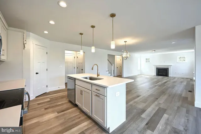a view of a kitchen with kitchen island a sink stainless steel appliances and cabinets