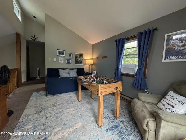 a living room with furniture a dining table and a refrigerator