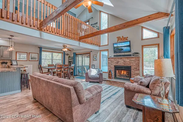 a living room with fireplace furniture and a large window