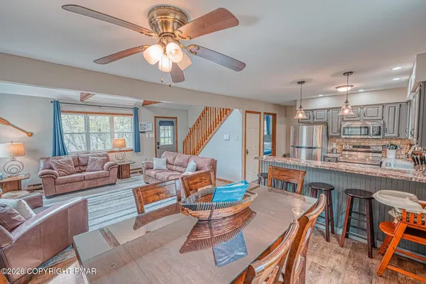 a living room with furniture kitchen view and a large window