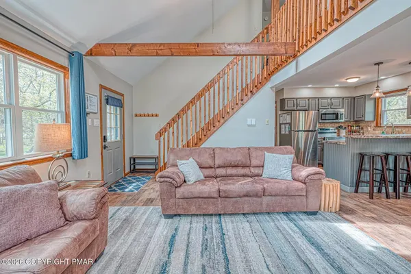 a living room with furniture and a wooden floor