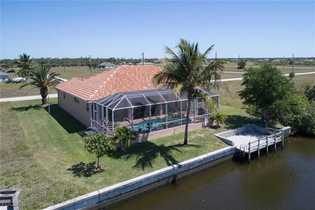 a view of a house with pool and a yard