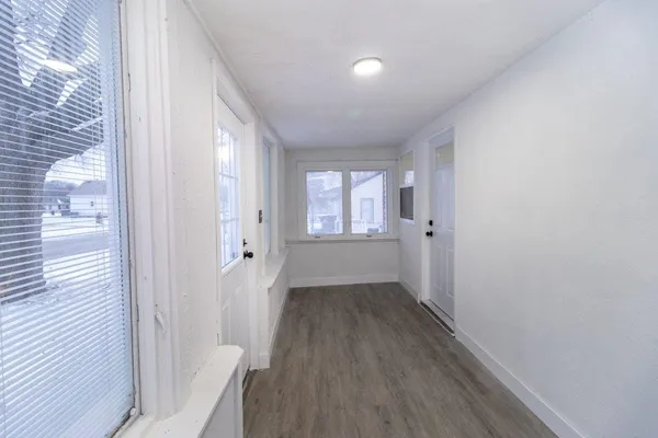 a view of a room with wooden floor and windows