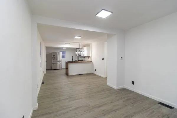 a view of a room with wooden floor and white walls
