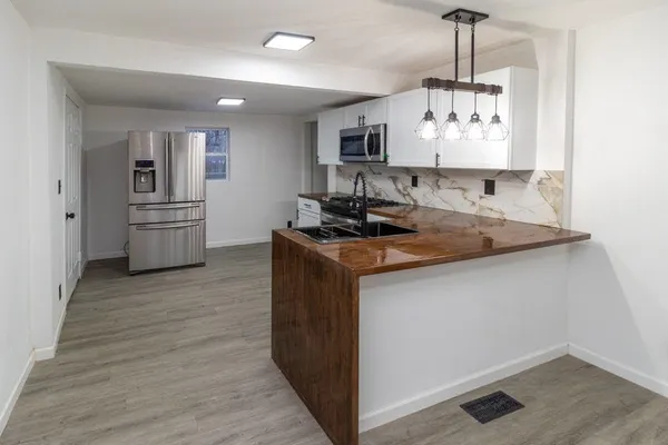 a kitchen with stainless steel appliances granite countertop a sink a stove a refrigerator and island