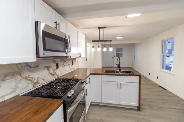 a kitchen with stainless steel appliances granite countertop a sink stove and cabinets