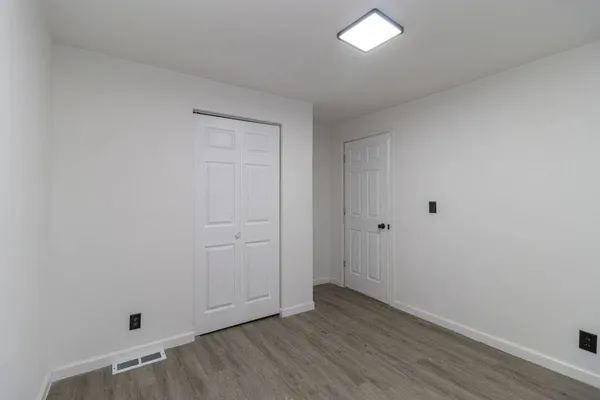 a view of an empty room with wooden floor