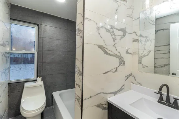 a white toilet sitting next to a bathroom sink