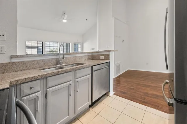 a kitchen with granite countertop white cabinets and sink