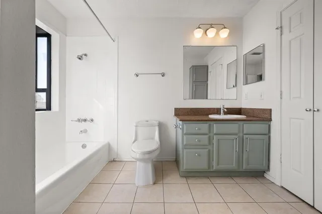 a bathroom with a granite countertop sink a toilet and shower