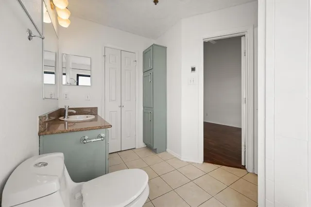 a bathroom with a granite countertop sink toilet and mirror