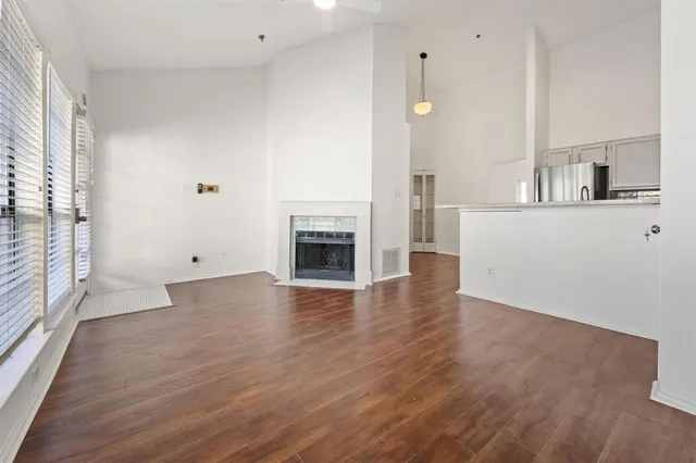 an empty room with wooden floor and a fireplace