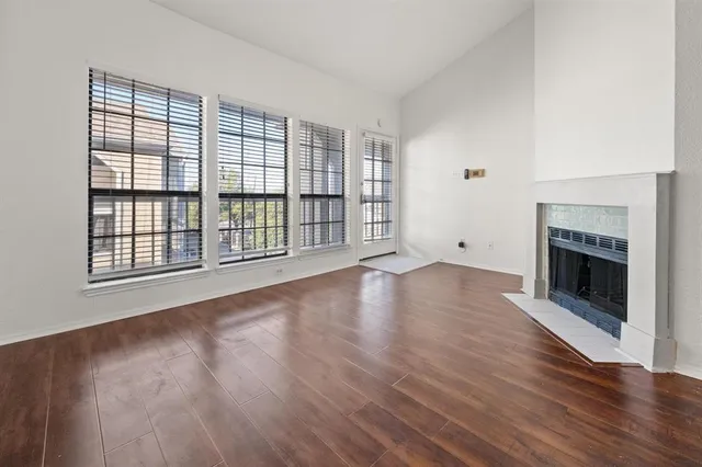wooden floor fireplace and windows in an empty room