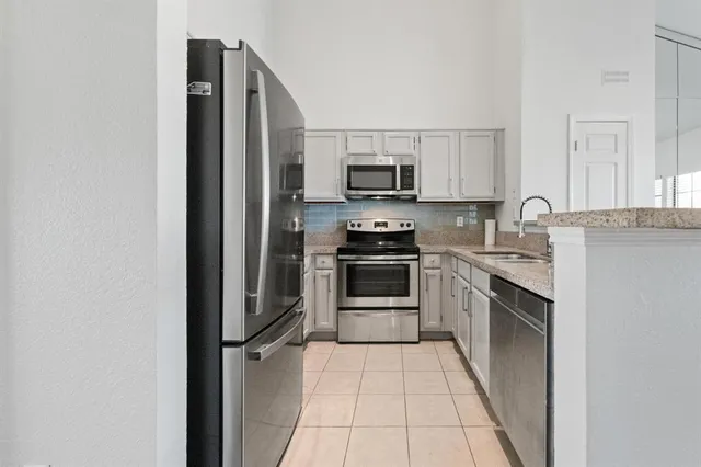 a kitchen with stainless steel appliances granite countertop a refrigerator sink and stove