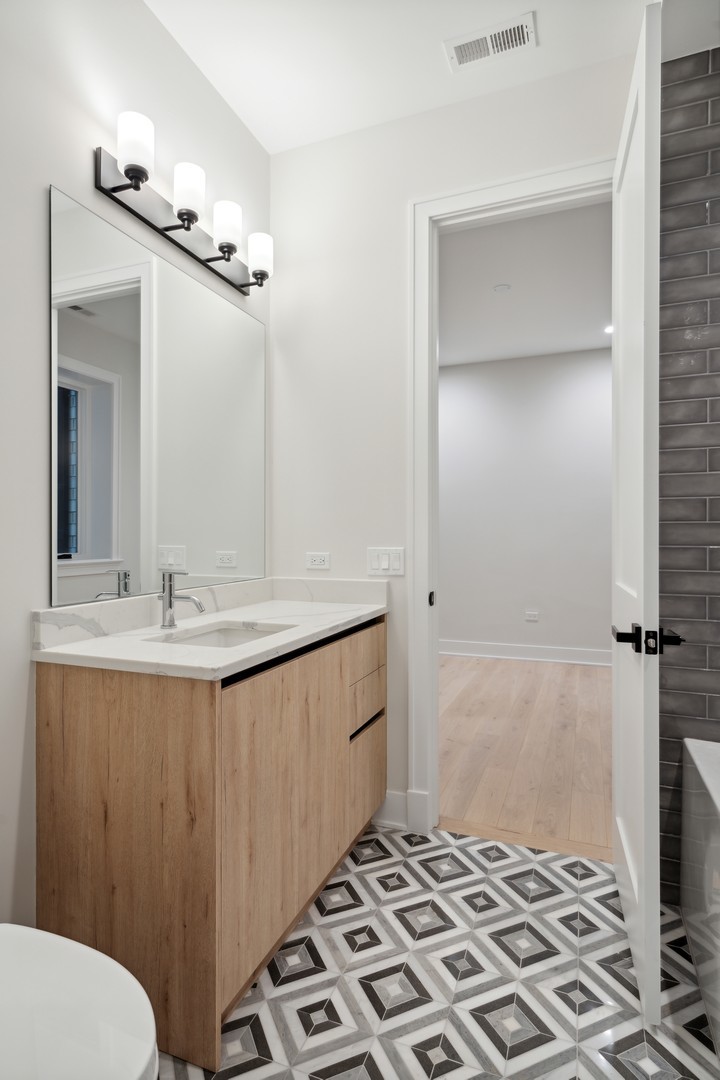 232 South Green Street, Unit 3S Chicago, IL 60607 - Photo 19 of 23 a bathroom with a sink a toilet a mirror and shower