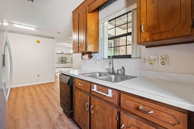 a view of an empty room with a window and cabinet