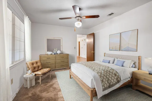 an empty room with a chandelier fan and closet