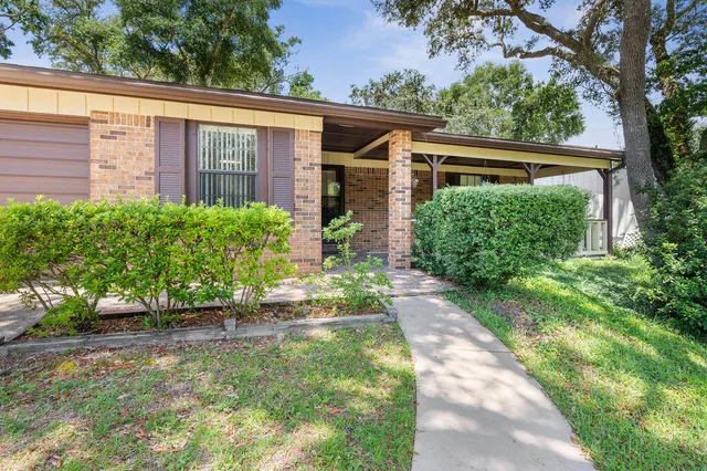 an empty room with wooden floor chandelier fan and windows