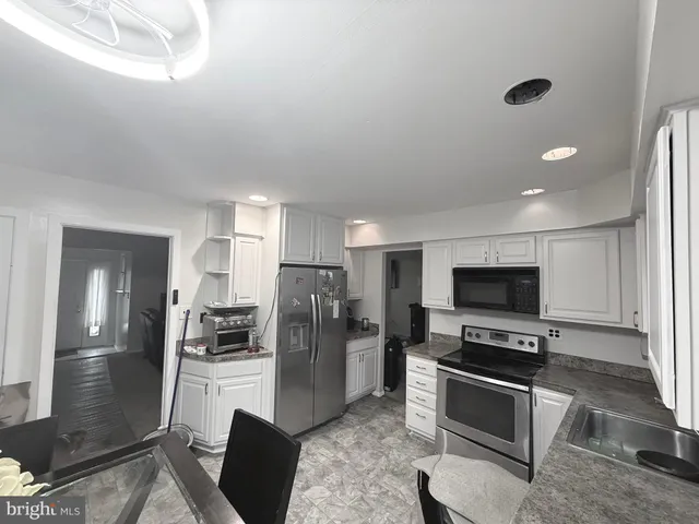 a kitchen with stainless steel appliances a refrigerator and a stove top oven