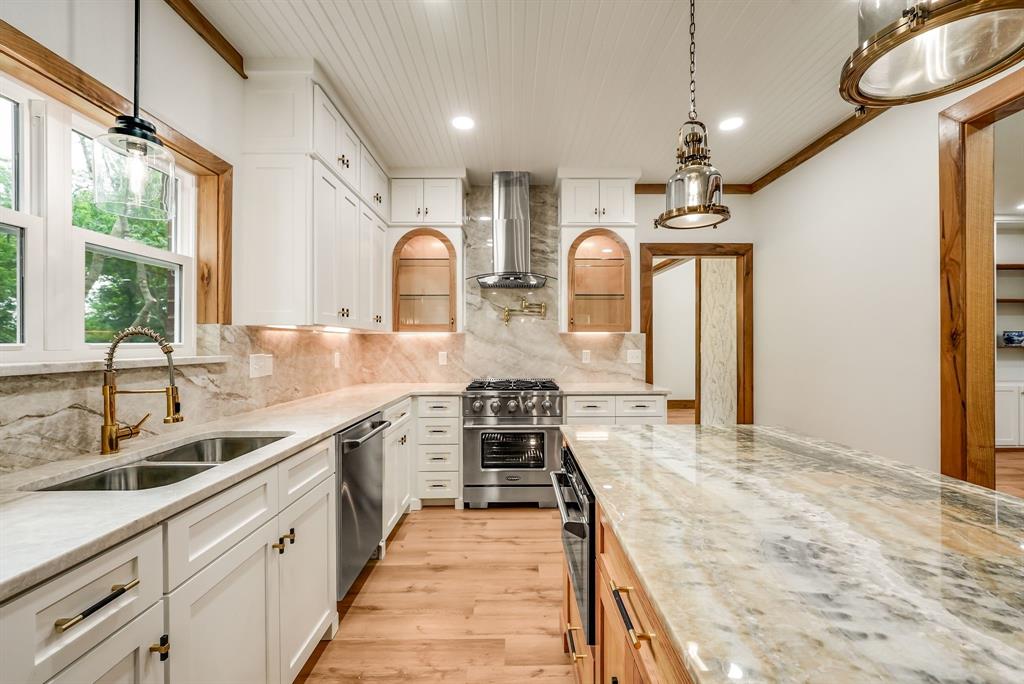 1037 Harrison Road Denison, TX 75021 - Photo 14 of 39 Gourmet kitchen featuring white shaker cabinetry, patterned stone countertops, stainless steel appliances, wood-finish flooring, and a beadboard ceiling