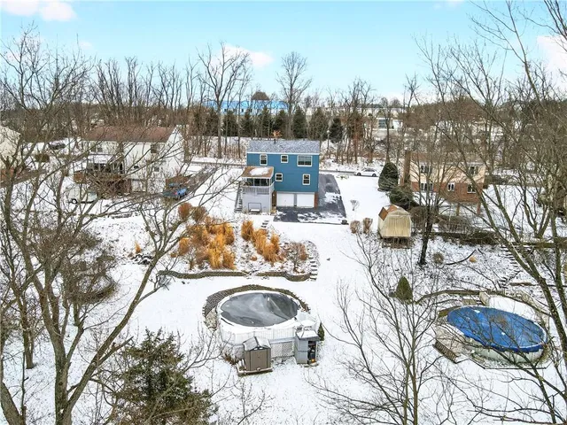 a view of a swimming pool with outdoor seating and trees in the background