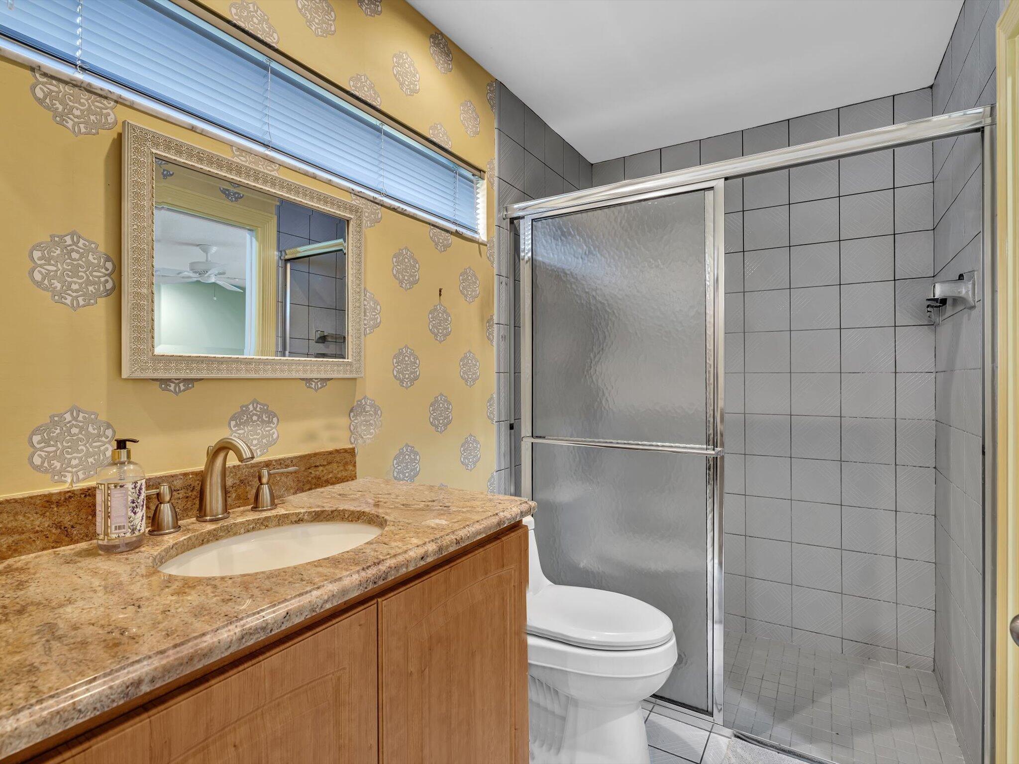 10122 Spyglass Way Boca Raton, FL 33498 - Photo 37 of 65 a bathroom with a granite countertop sink toilet and shower
